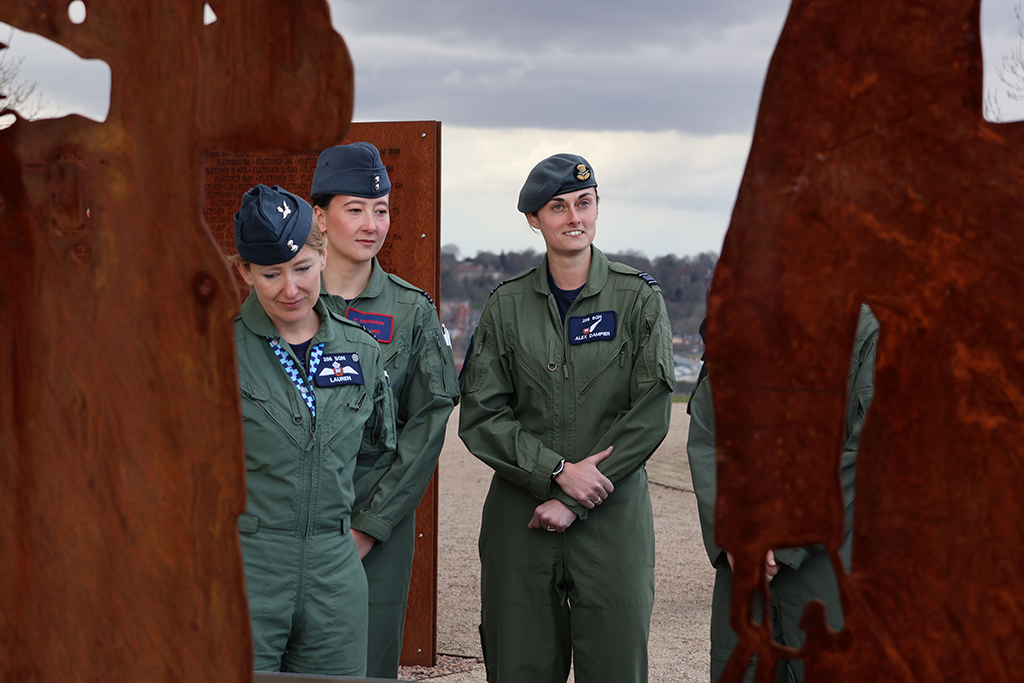 Photo: Flypast aircrew standing in front of memorial silhouettes.